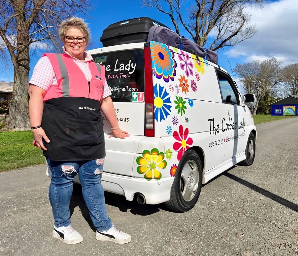 The Coffee Lady standing beside her colourful coffee van